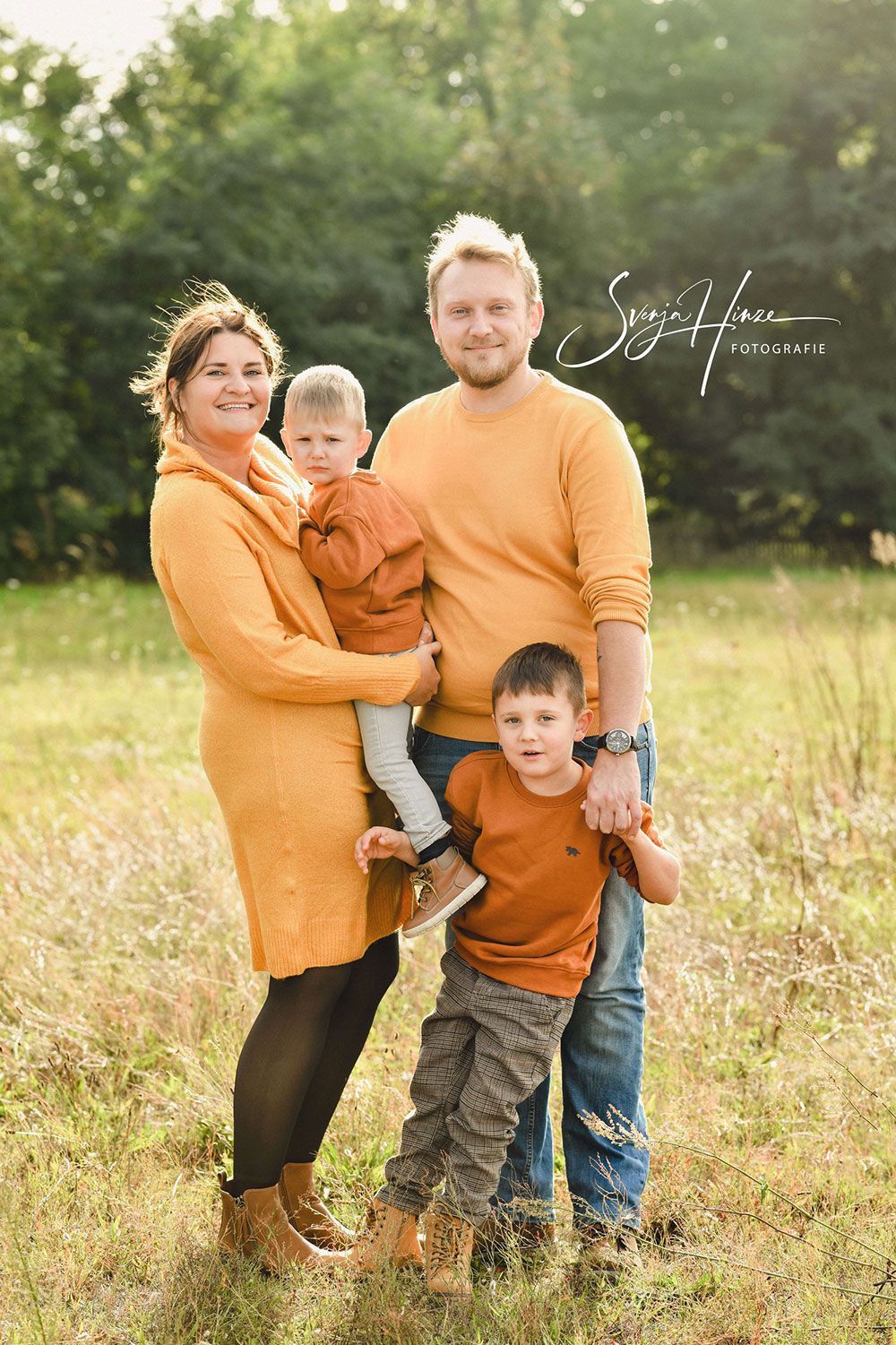 Eine Familie posiert auf einem Feld für ein Foto.