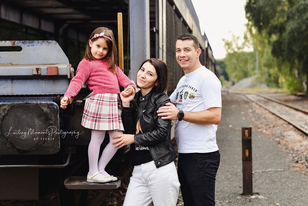 Eine Familie posiert vor einem Zug für ein Foto.