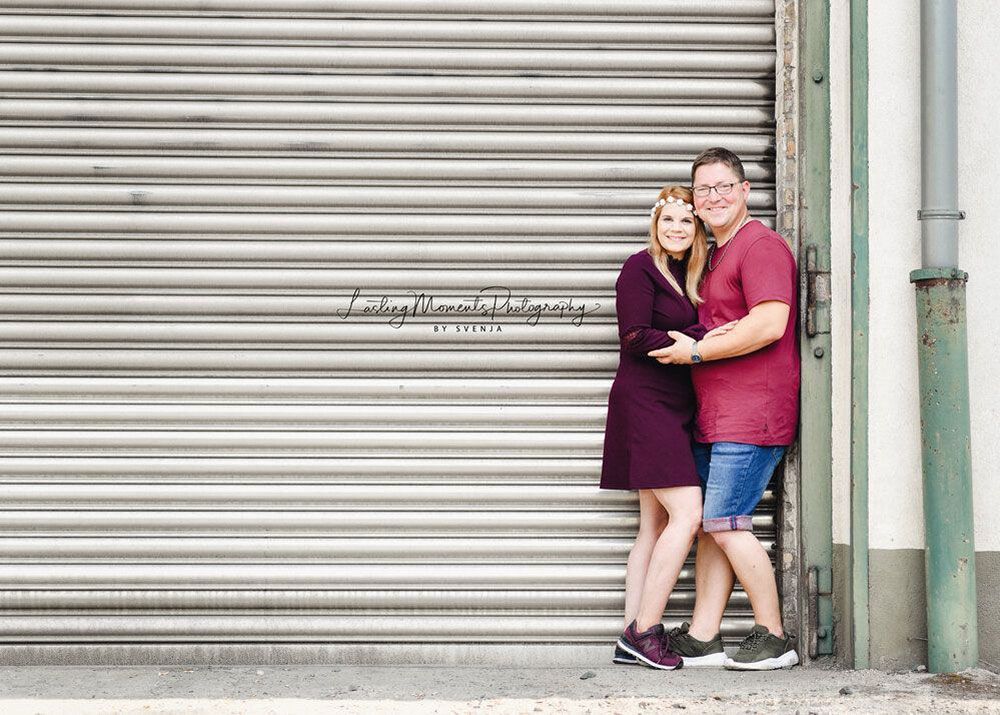 Ein Mann und eine Frau stehen nebeneinander vor einem Garagentor.