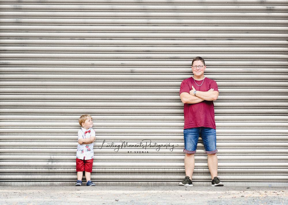 Ein Mann und ein Junge stehen nebeneinander vor einem Garagentor.