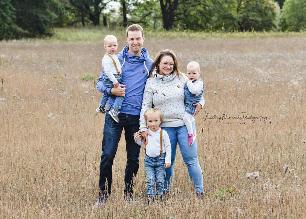 Eine Familie posiert auf einem Feld für ein Foto.