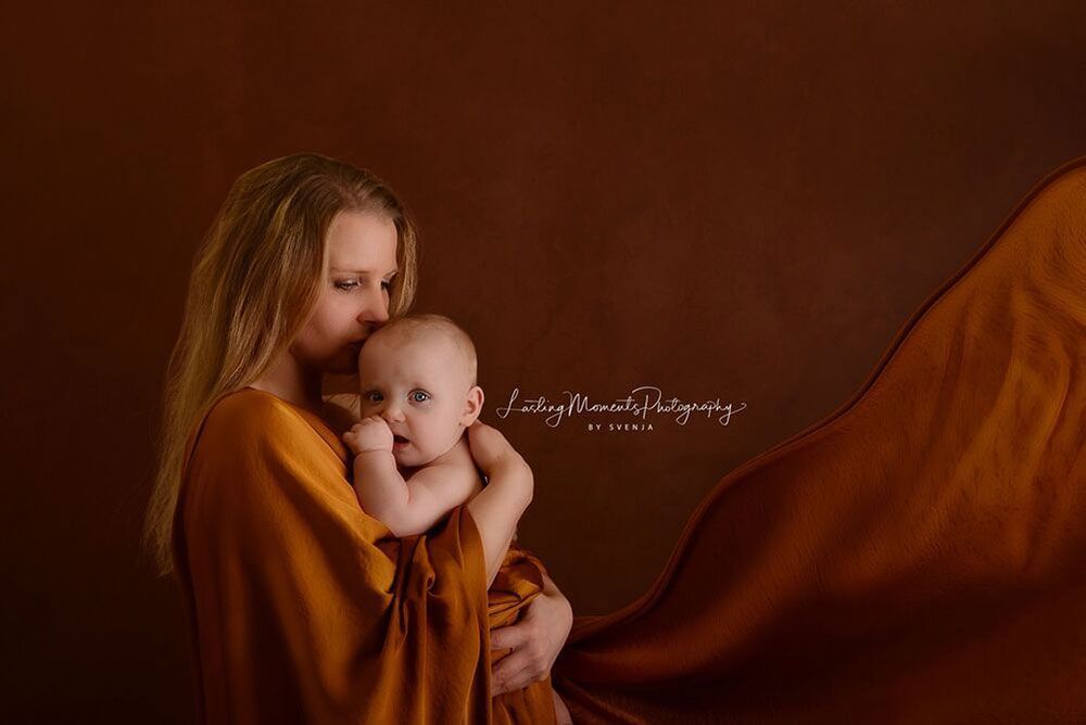 Eine Frau hält ein in eine Decke gewickeltes Baby.