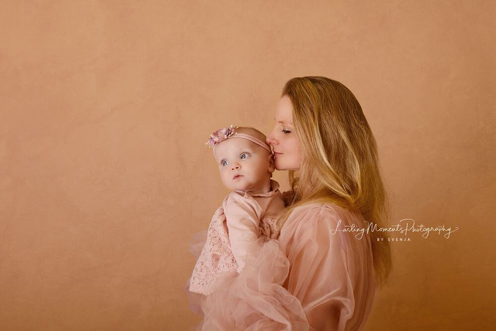 Eine Frau küsst ein Baby auf die Wange.