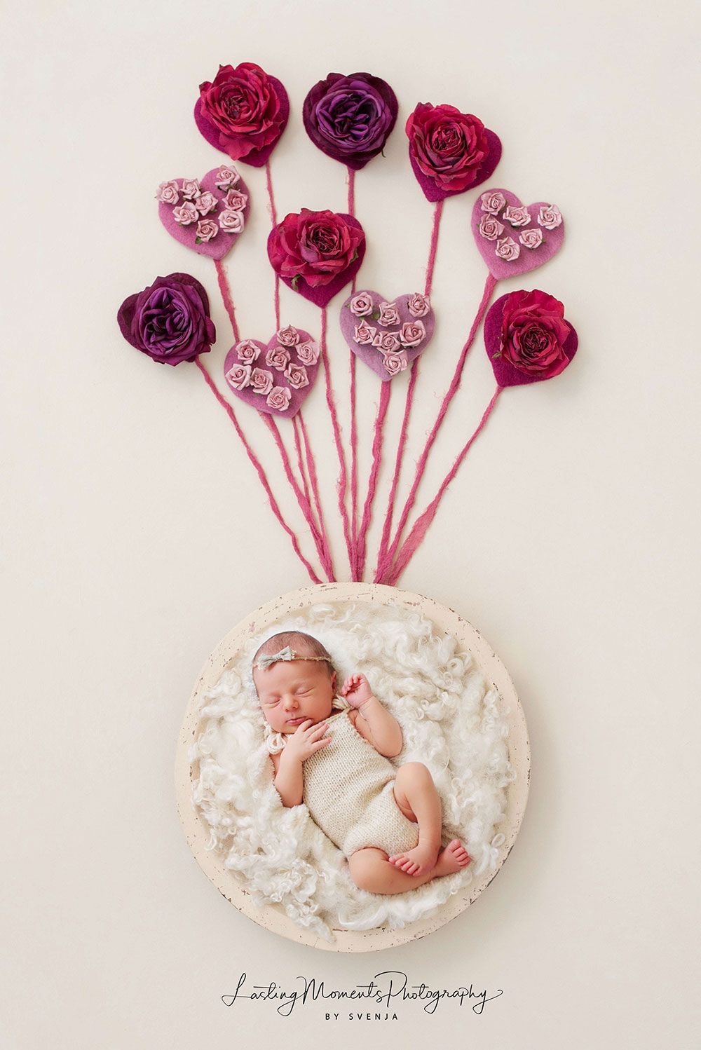 Ein Baby liegt in einem Kreis, umgeben von Blumen und Herzen.