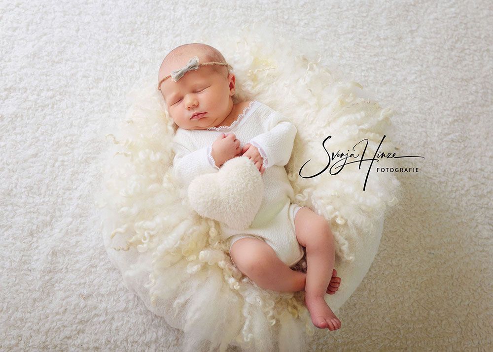 Ein Neugeborenes liegt auf einer weißen Decke.