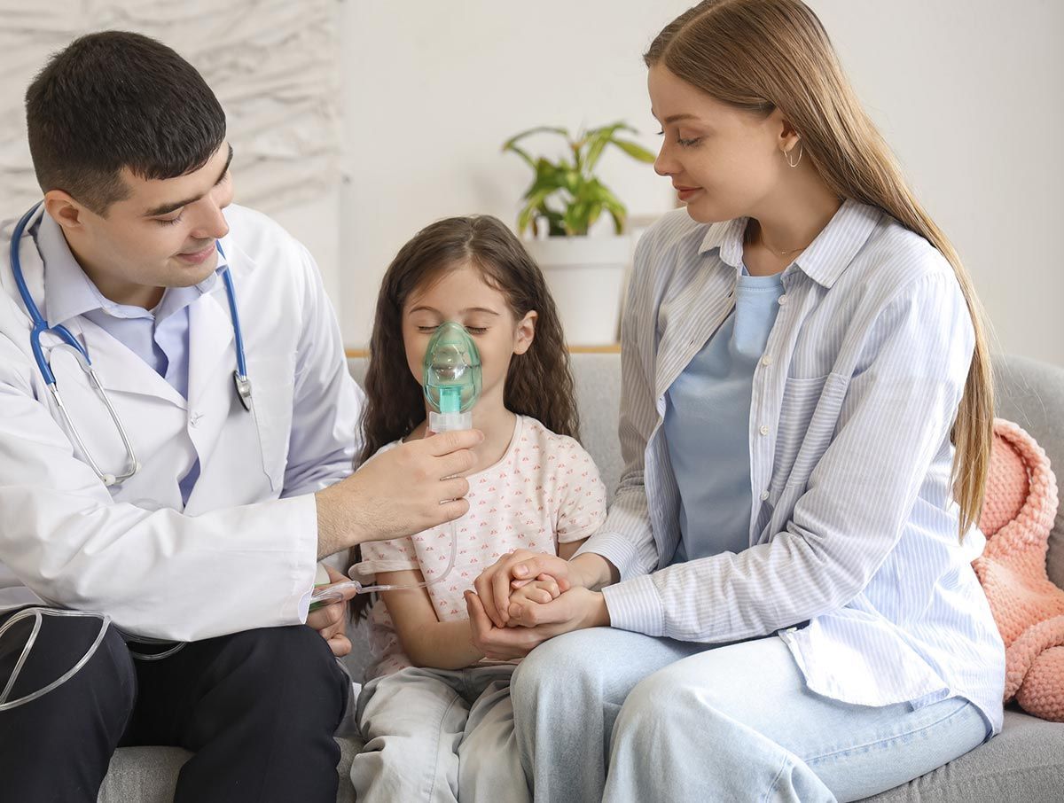 Un médico le está dando una máscara de oxígeno a una niña.