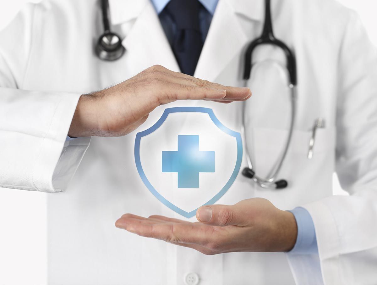 Un médico sostiene un escudo con una cruz.