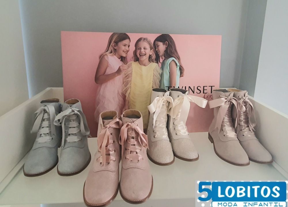 Una exhibición de zapatos de niños con un cartel que dice 5 lobitos