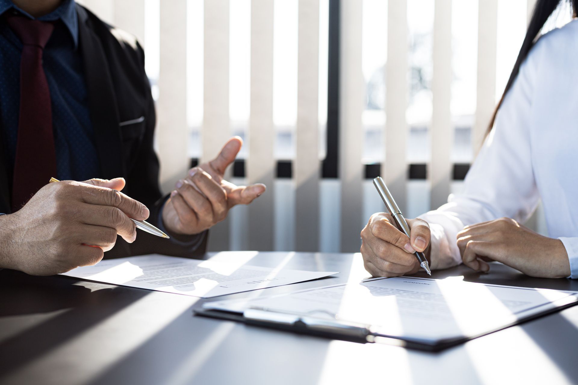 L'agent d'assurances habitation et le client signent un contrat d'assurance avec leur compagnie d'assurances, acceptant les conditions et les garanties.