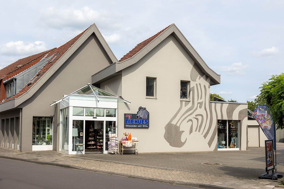 Außenansicht des Ladens im Zebra-Stil mit einem großen Zebra-Wandgemälde und einem Glaseingang.