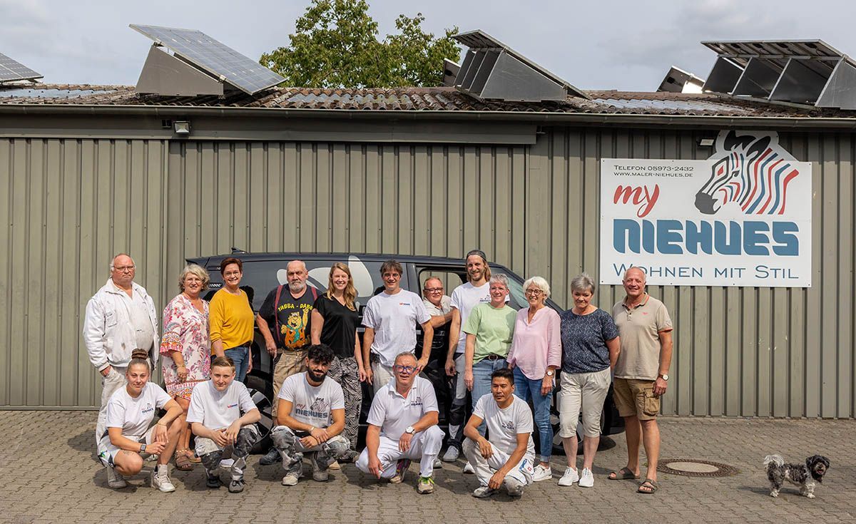Gruppe von Menschen posiert vor einem Gebäude mit einem Zebra-Logo.