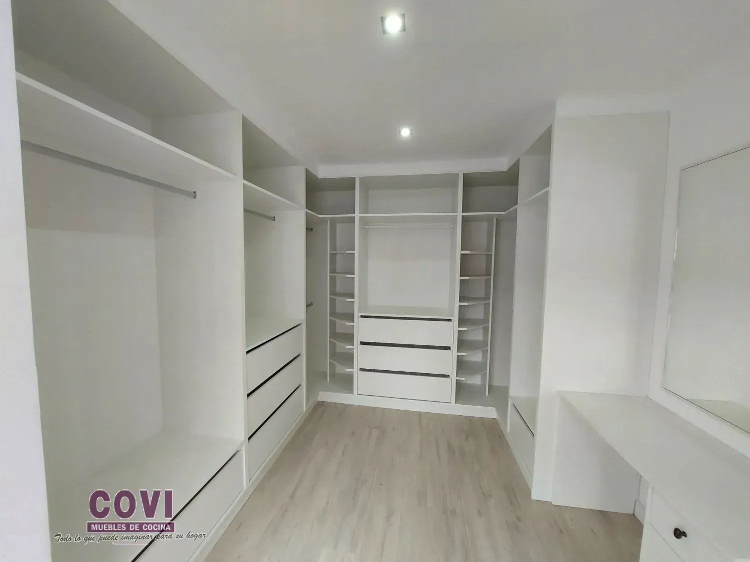 Vestidor blanco con estantes, cajones y barras para colgar. Incluye tocador con espejo.