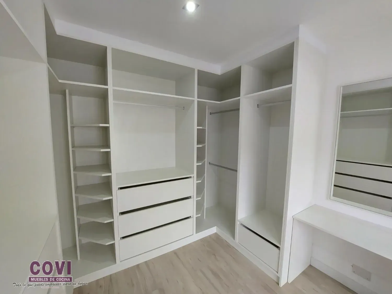 Vestidor blanco con estantes, cajones y barras para colgar. Incluye tocador con espejo.