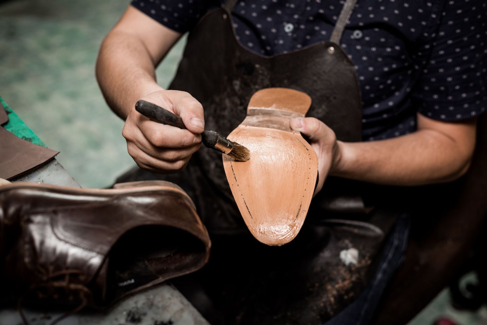 Un hombre está lustrando un zapato con un cepillo.