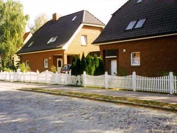 zwei Häuser mit einem weißen Zaun