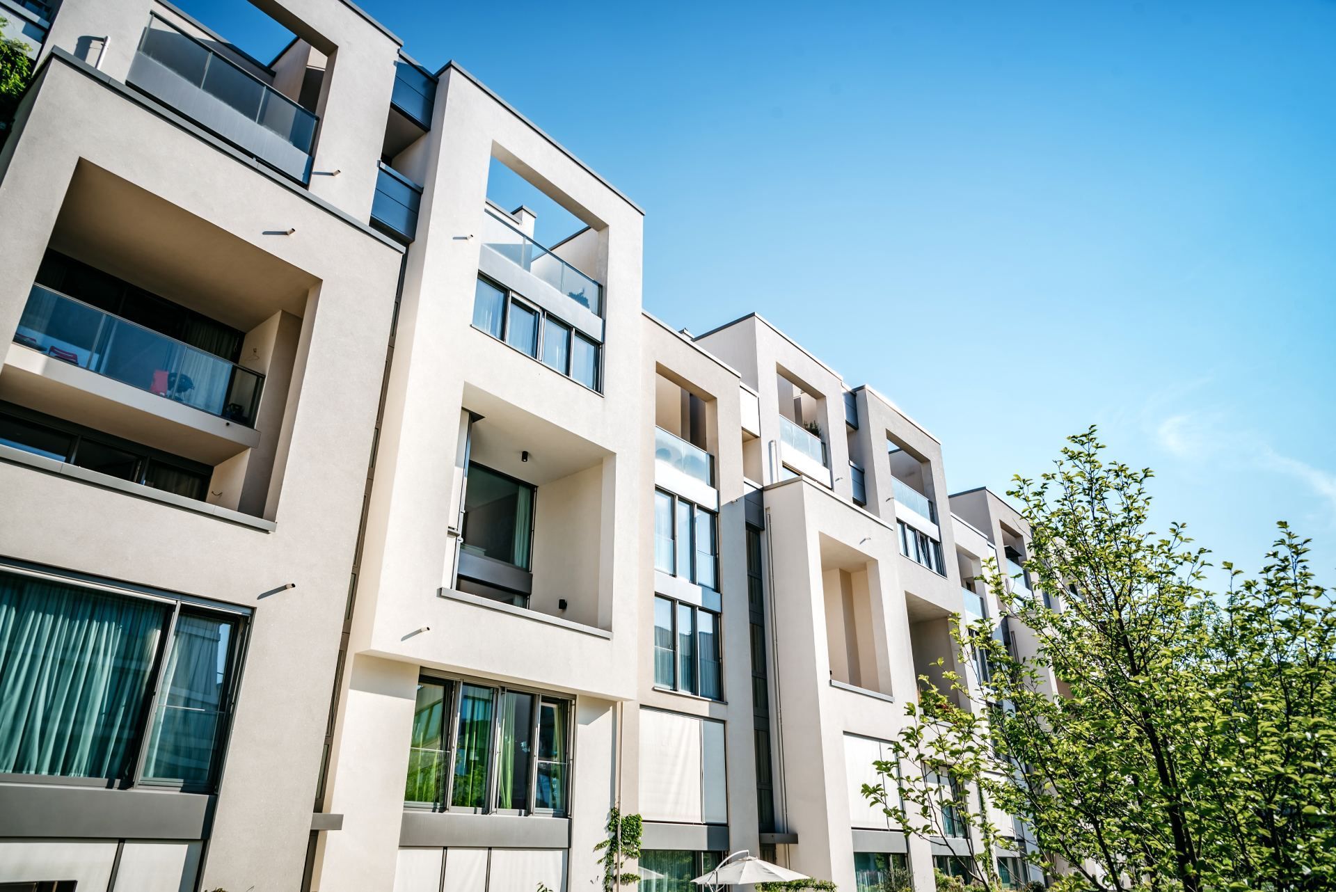 Moderne appartementencomplexen met balkons onder een helderblauwe hemel.