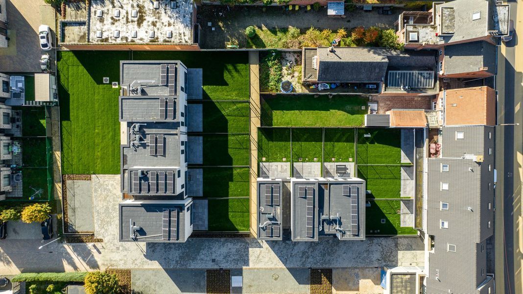 Luchtfoto van moderne appartementencomplexen met groene gazons en verharde wandelpaden.