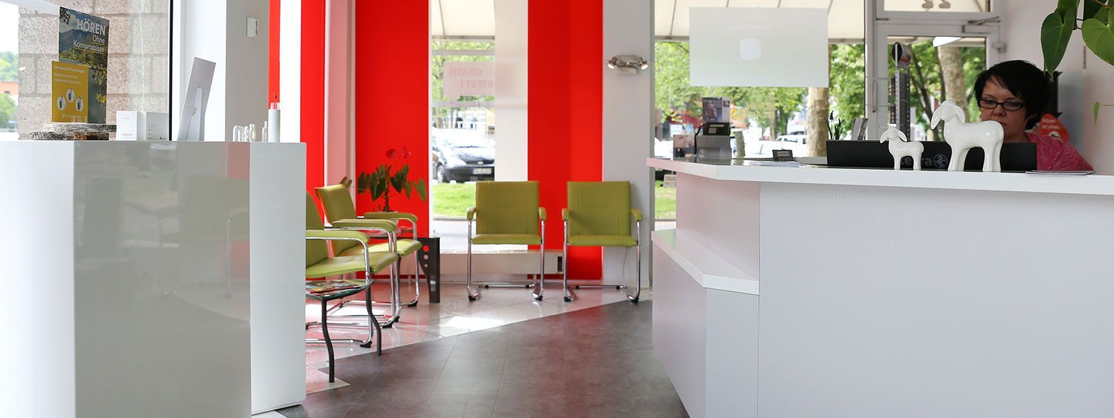 Eine Frau sitzt an einem Schreibtisch in einem Wartezimmer