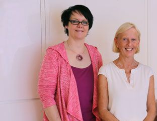 Drei Frauen posieren zusammen für ein Foto und lächeln in die Kamera.