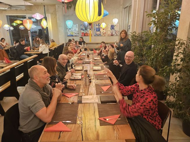 Eine Gruppe von Menschen sitzt an einem langen Tisch in einem Restaurant.