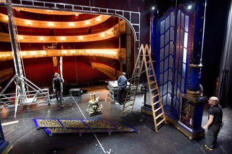 Un grupo de personas está trabajando en un escenario en un teatro.