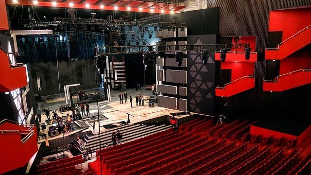 Un gran auditorio con asientos rojos y un escenario.