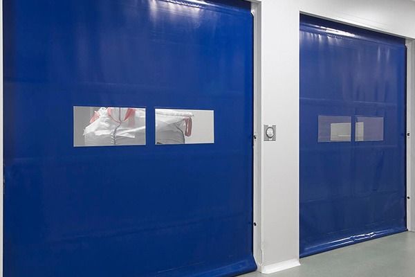 Una habitación con dos puertas azules y un espejo en la pared.