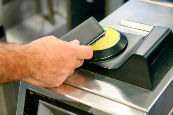Una persona está usando un teléfono inteligente para ingresar a una máquina.
