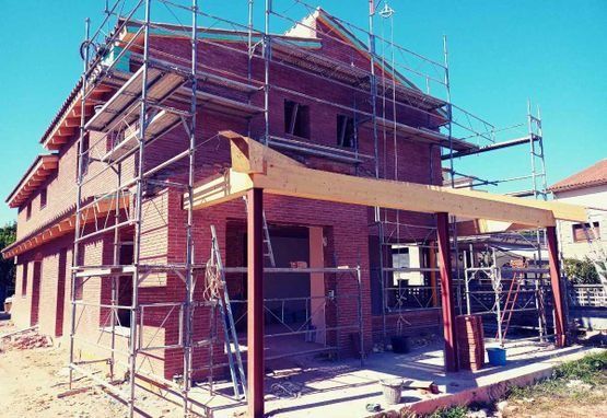 Se está construyendo una casa de ladrillo con andamios alrededor.