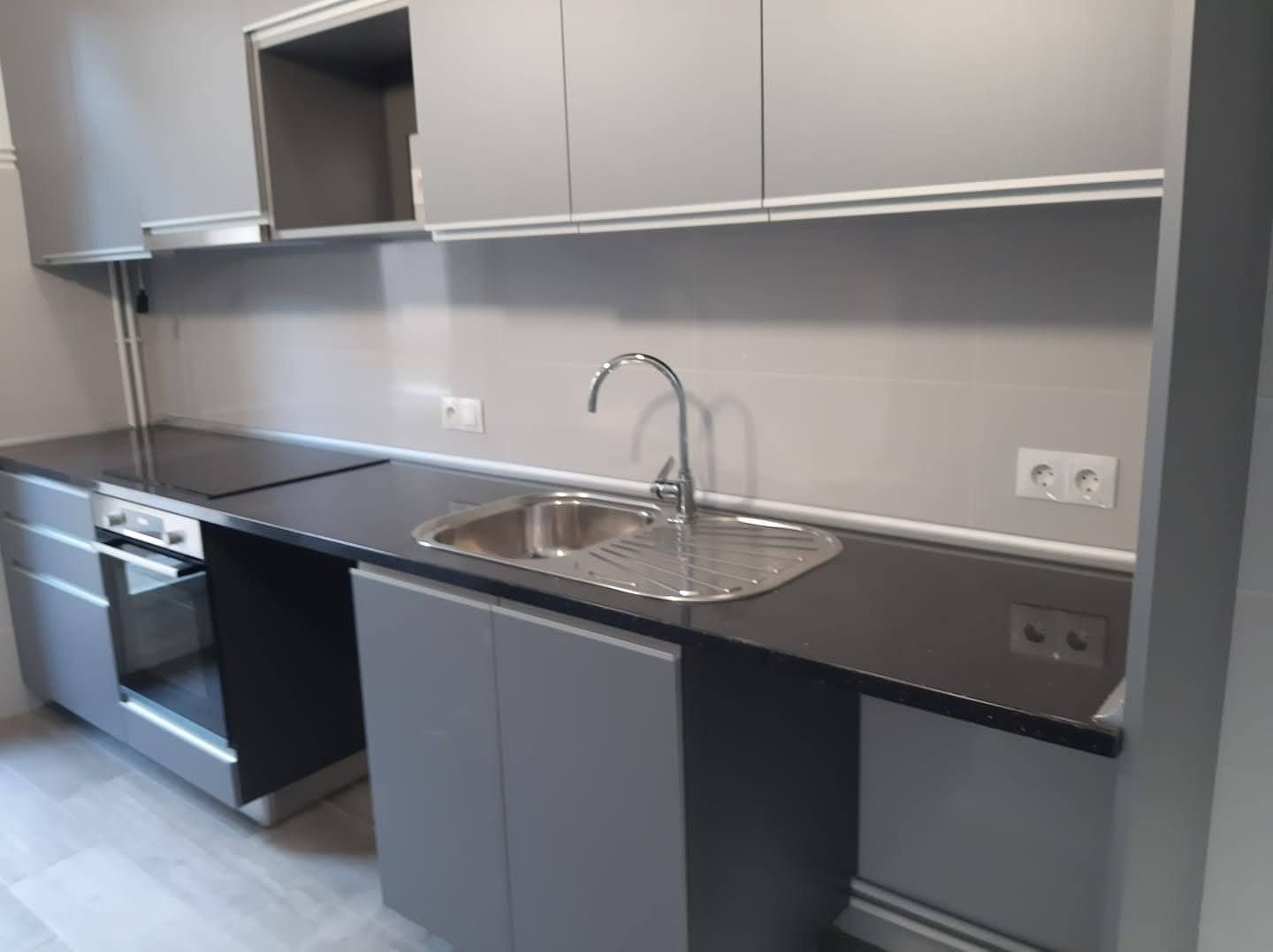 Una cocina con fregadero y horno de cocina.