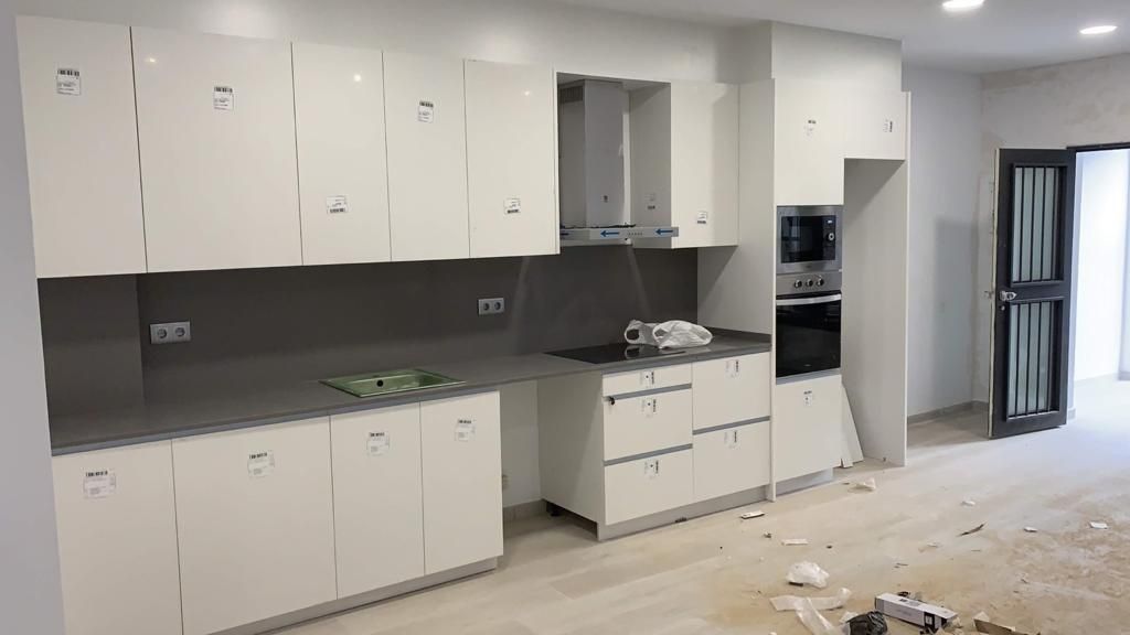 Una cocina con gabinetes blancos y un horno de estufa.