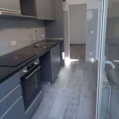 Una cocina con estufa, horno, fregadero y gabinetes.
