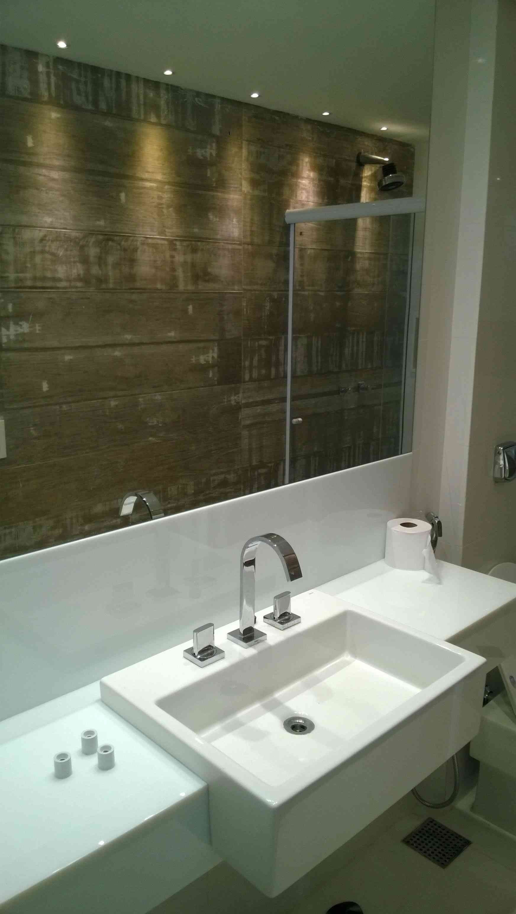 Un baño con lavabo, espejo y cabina de ducha.