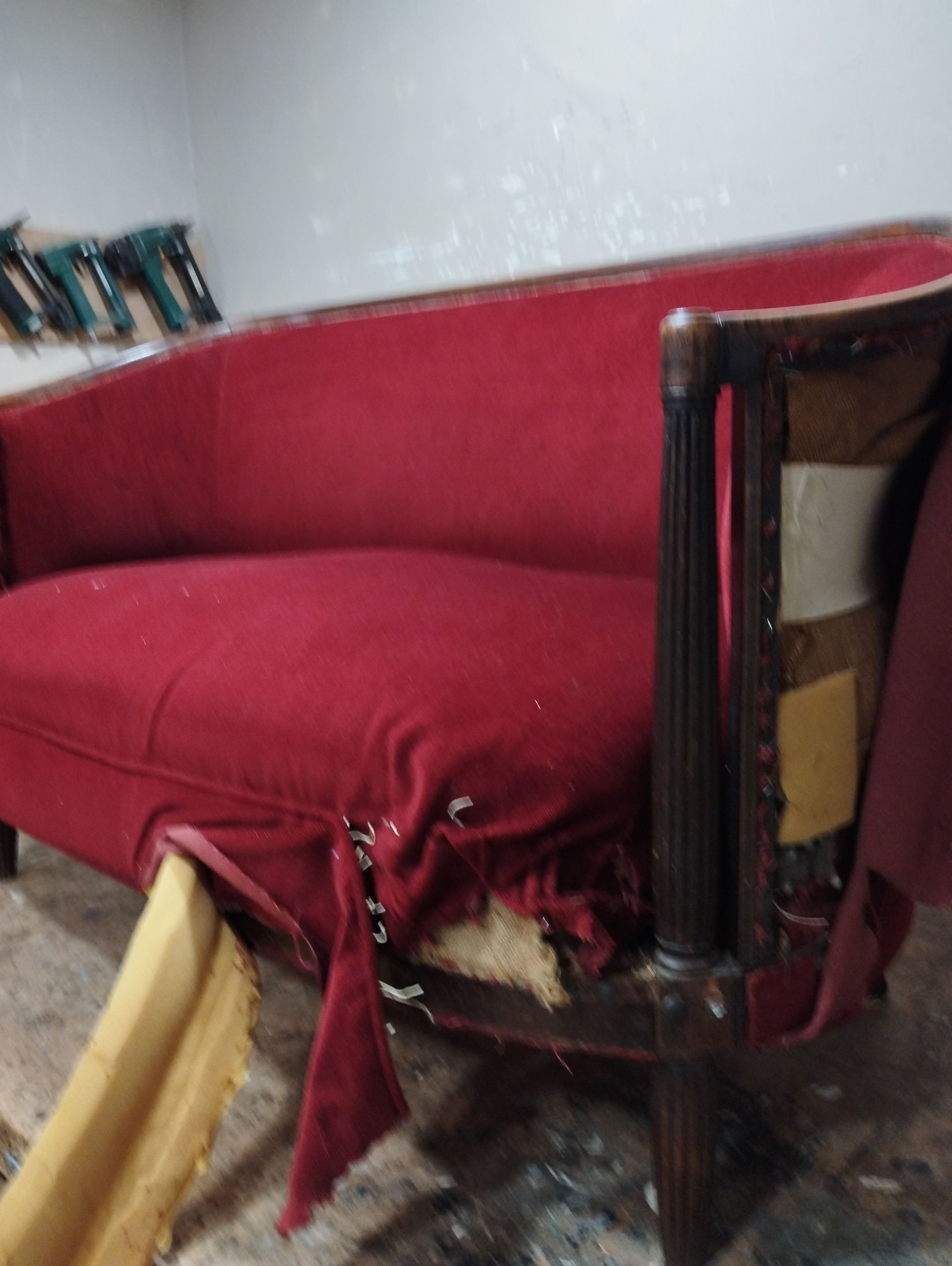 Canapé rouge abîmé sur le côté