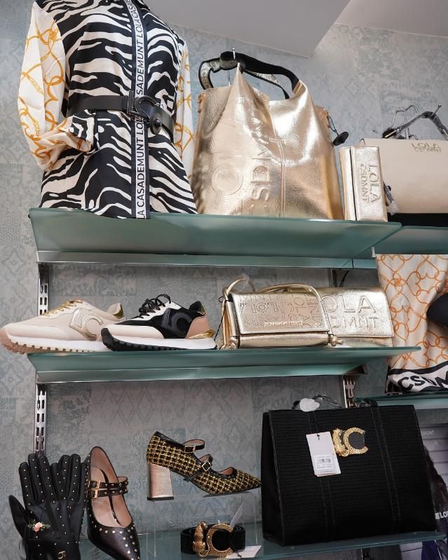 Ropa y accesorios expuestos en los estantes de una tienda.