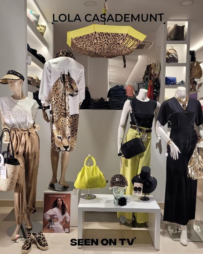 Escaparate de una tienda de ropa con maniquíes con trajes. Estampados en amarillo, negro y animal print. 