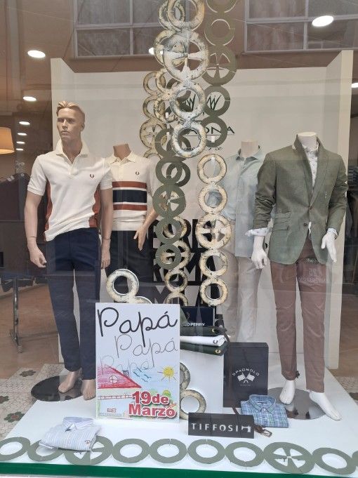 Escaparate de una tienda de ropa para hombre. Maniquíes con polos, chaqueta y pantalones. 