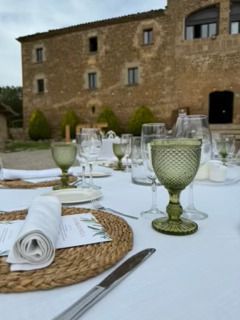 Una mesa con platos, velas, copas de vino y un menú sobre ella.