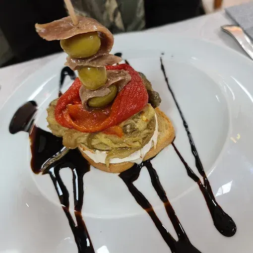 Un primer plano de un plato de comida con salsa encima.