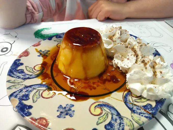 Un plato de postre con crema batida y salsa de caramelo.