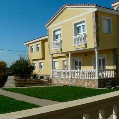 Una gran casa amarilla con muchas ventanas y balcones.