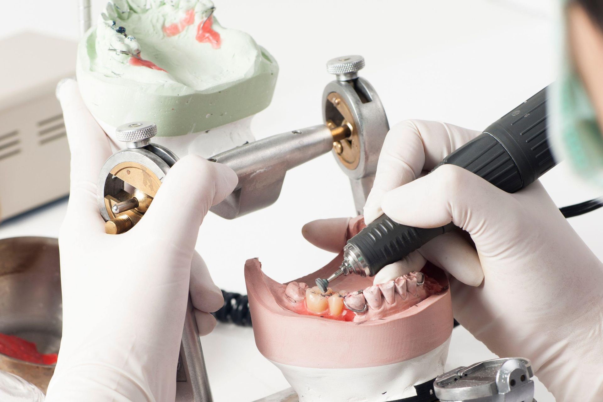 Un dentista está trabajando en un modelo de los dientes de una persona.
