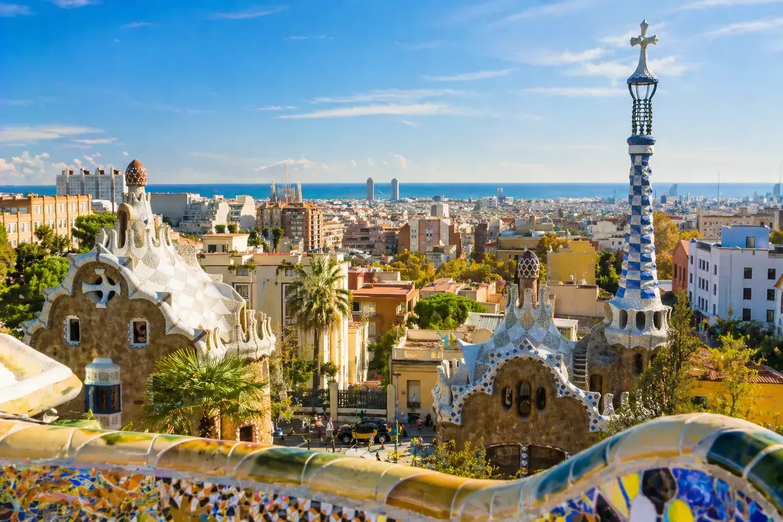 Vista panorámica  del Parque Güell con vistas a Barcelona bajo un cielo azul brillante.