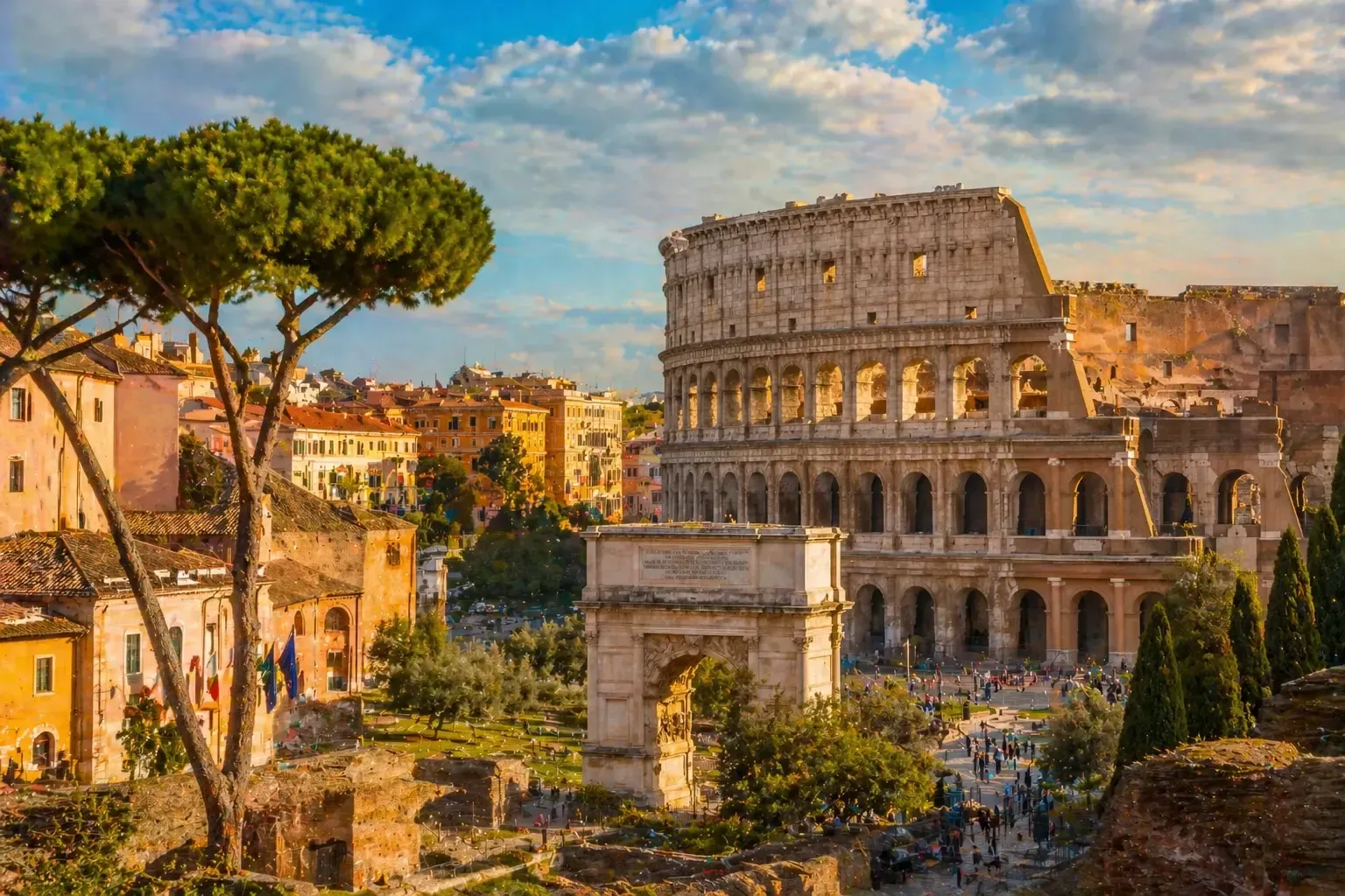 El antiguo Coliseo romano al atardecer, junto a árboles y edificios de la ciudad bajo un cielo azul.