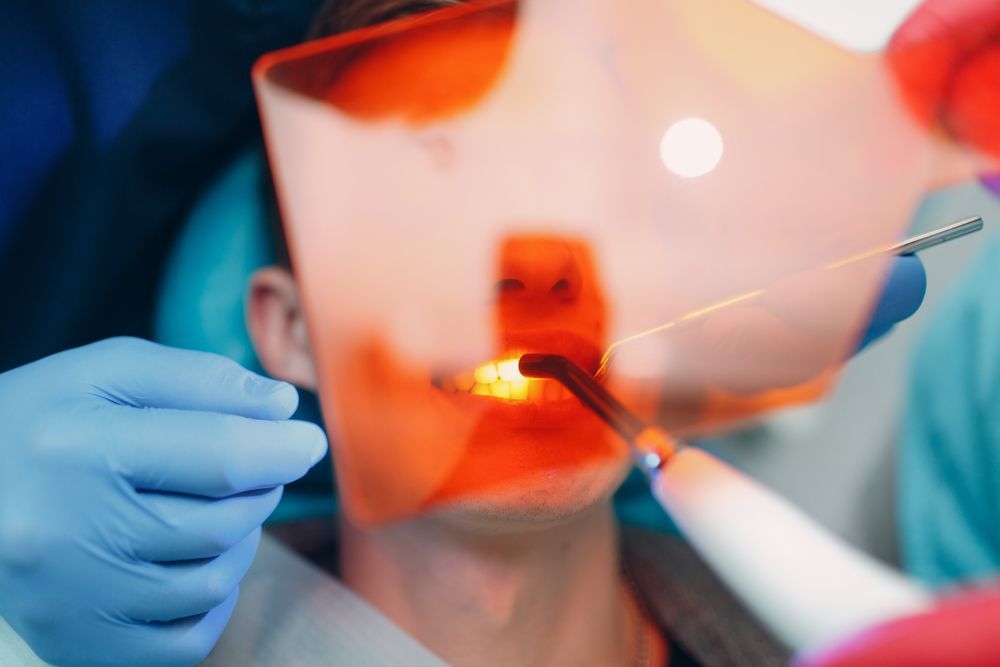 Un dentista está examinando los dientes de un paciente con una luz.