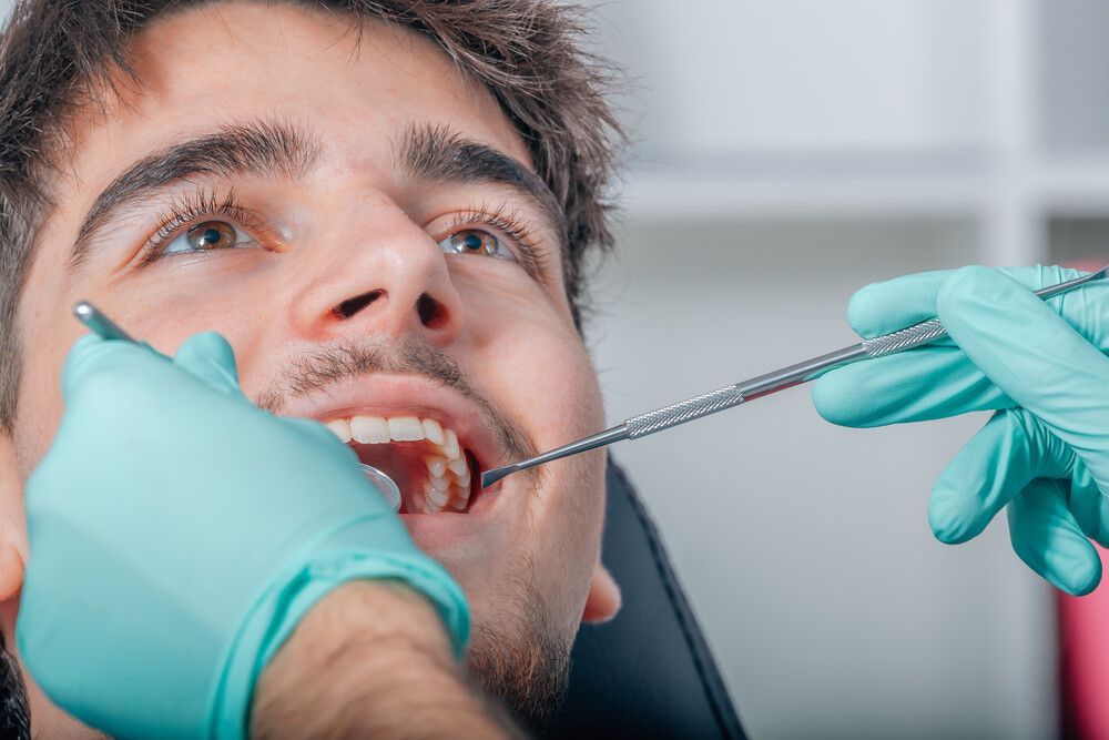 Un hombre está siendo examinado por un dentista.