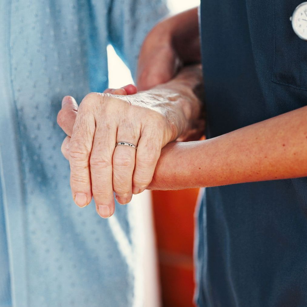 Une infirmière supporte une personne âgée