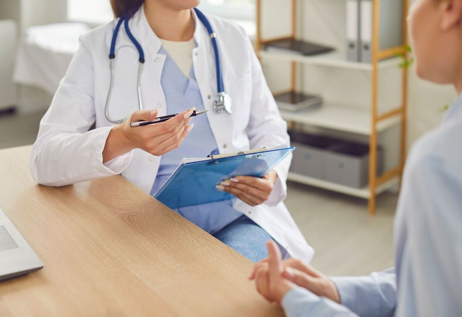 Une infirmière à son bureau interroge un patient