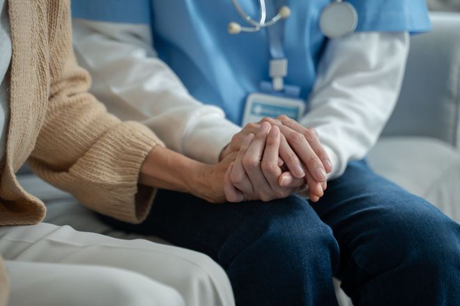 Un soignant tient les mains d'un patient