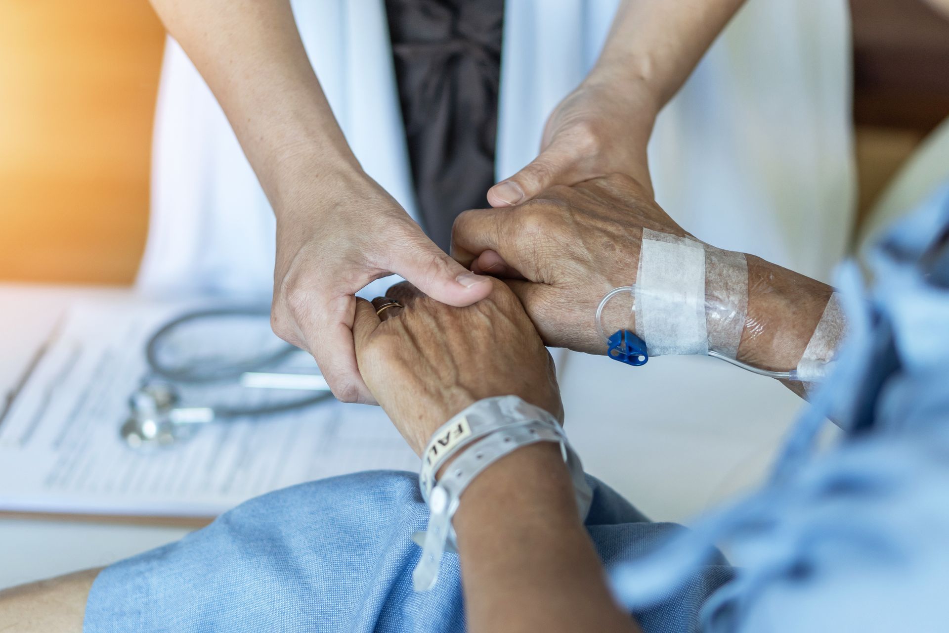 Un patient et une infirmière se tiennent les mains gentiment